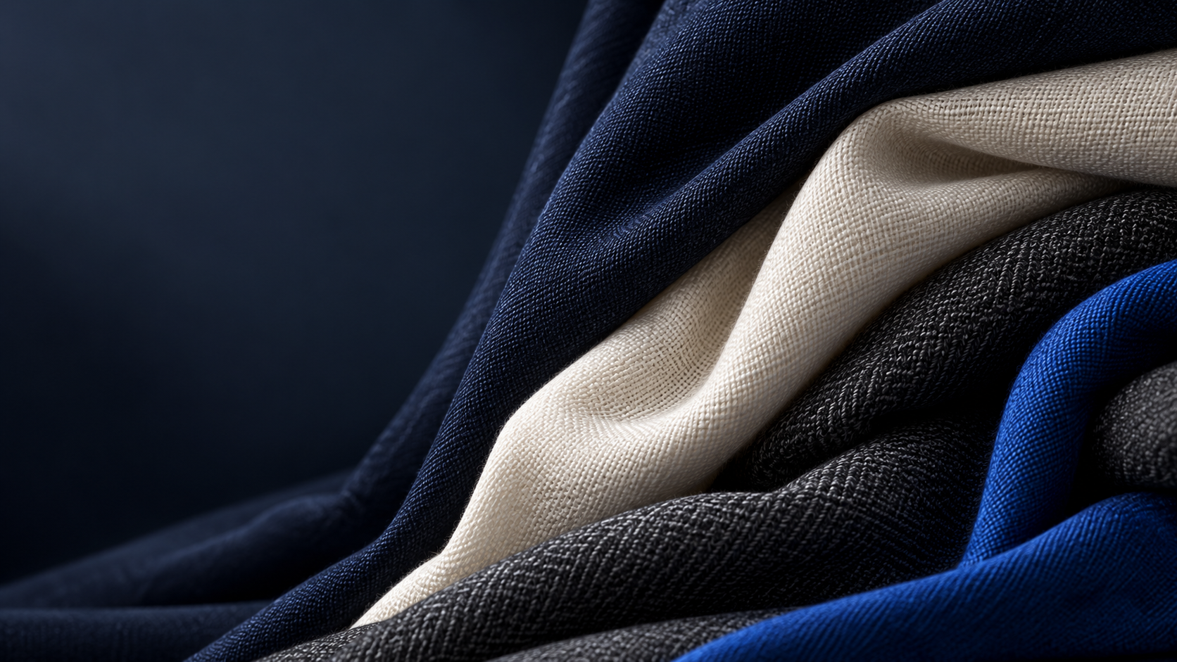 Pliegues textiles en tonos azul marino, marfil, carbón y cobalto; imagen ilustrativa